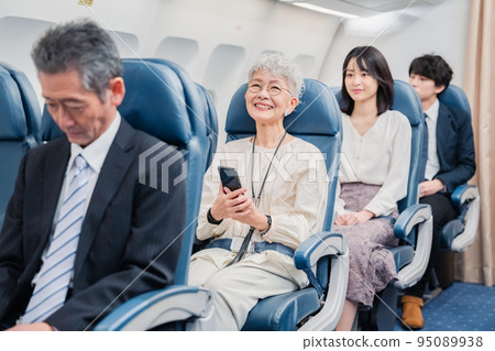 Passengers spending time on board an airplane Passengers spending time on board an airplane 95089938