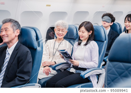 Passengers spending time on board an airplane Passengers spending time on board an airplane 95089941