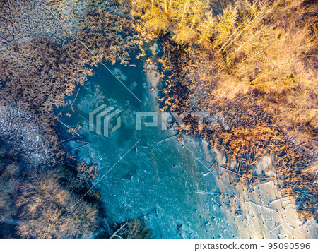 Aerial view on frozen wild lake in sunset forest Aerial view on frozen wild lake in sunset forest 95090596