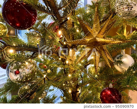 Scenery with sparkling light bulbs and ornaments on the Christmas tree 95090970