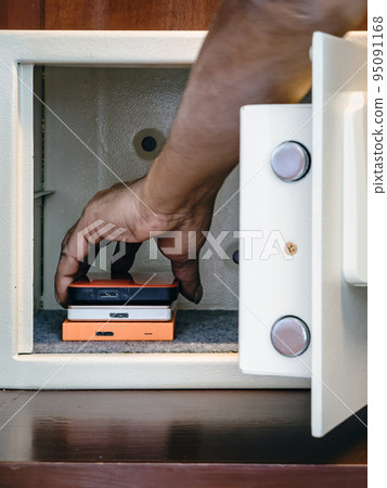 Security external hard drive in open metal safe. External hard disk containing confidential and important information keep well in white safe box. Confidentiality and Importance of Information Concept Security external hard drive in open metal safe. External hard disk containing confidential and important information keep well in white safe box. Confidentiality and Importance of Information Concept 95091168