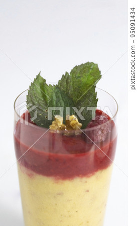 serving of homemade double layer smoothie with fresh berries yogurt, banana, mint leaves and walnut in glasses on white background, Diet and weight loss control concept, Vertical format 95091434