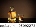 close up view of bottle of brandy and glass aside on color back.  95092272