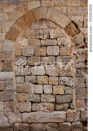 Middle Ages arch in a stone wall in France Middle Ages arch in a stone wall in France 95092804