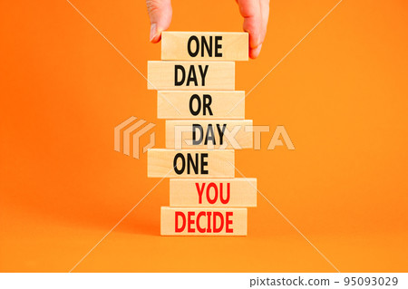 Day one symbol. Concept words One day or day one you decide on wooden blocks on a beautiful orange table orange background. Businessman hand. Business motivational and day one concept. 95093029