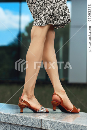 Bare legs of woman in peep toe sandals 95093258