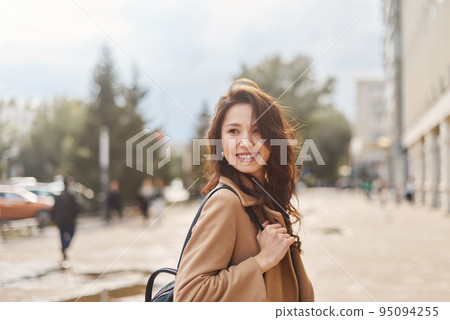 Lifestyle portrait pretty Asian kazakh woman with brilliant smile on street 95094255