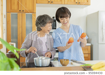 A female caregiver who prepares a meal with a user A female caregiver who prepares a meal with a user 95094430