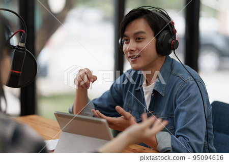 Podcaster making audio podcast working with guest at home studio 95094616
