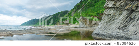 coastal landscape, panorama with beautiful columnar basalt cliff on the wooded coast of Kunashir island coastal landscape, panorama with beautiful columnar basalt cliff on the wooded coast of Kunashir island 95094626