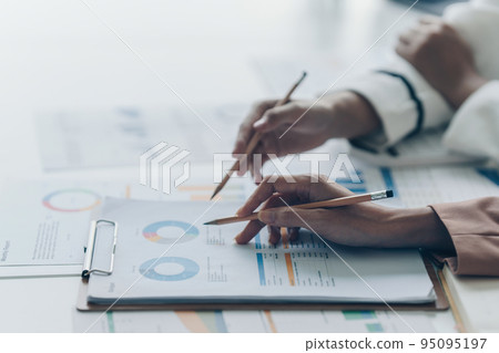 Business team support and meeting concept. Group of Investor working and pointing at financial paperwork Finance task on office desk 95095197