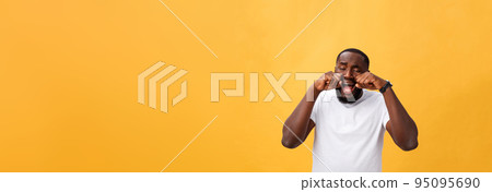 Young Stressed man with hand on his face showing sadness and despair. Isolated over yellow background. 95095690