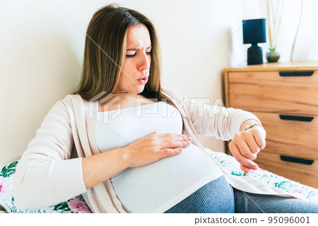 Pregnant time go hospital. Pregnant holding baby belly, woman watching clock. Childbirth time, contractions pain. Concept maternity, pregnant, childbirth. Pregnant time go hospital. Pregnant holding baby belly, woman watching clock. Childbirth time, contractions pain. Concept maternity, pregnant, childbirth. 95096001