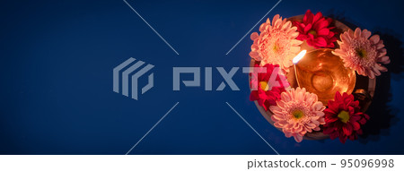 Happy Diwali. Traditional diya oil lamps and red flowers on blue background. Celebrating Hindu Light Festival. 95096998