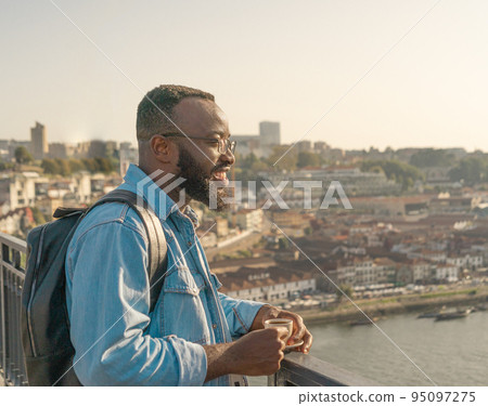 Traveller man drinking coffee on the Oporto bridge 95097275
