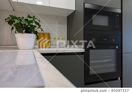 Marble worktop of modern white and dark grey kitchen Marble worktop of modern white and dark grey kitchen 95097337