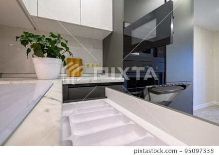 Marble worktop of modern white and dark grey kitchen 95097338
