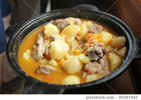 stewed potatoes with vegetables and shurpa meat in a close-up cauldron. Homemade food. Food in nature. delicious national dish stewed potatoes with vegetables and shurpa meat in a close-up cauldron. Homemade food. Food in nature. delicious national dish 95097492