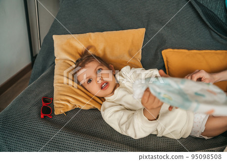 Adorable little girl with the nappy in her hands Adorable little girl with the nappy in her hands 95098508