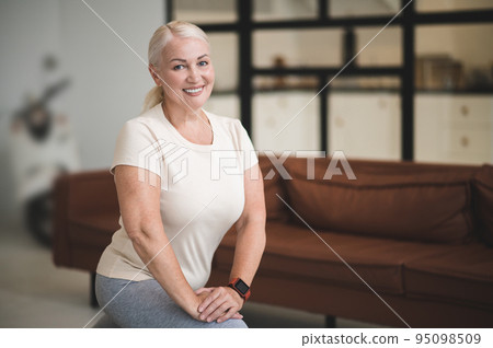 Joyful female working out in the living room Joyful female working out in the living room 95098509