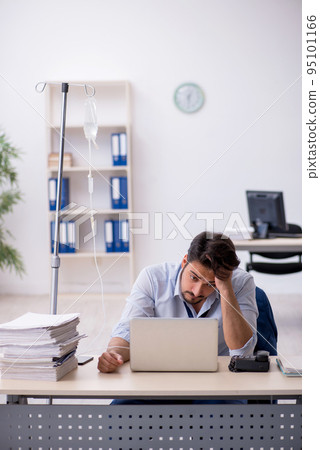 Young male employee suffering at workplace Young male employee suffering at workplace 95101166