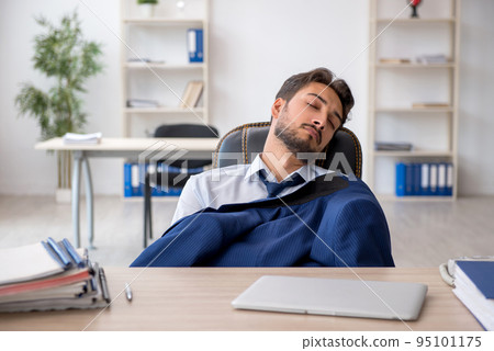 Young male employee extremely tired in the office 95101175
