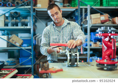 Worker fixing pipe fitting in repair service Worker fixing pipe fitting in repair service 95102024