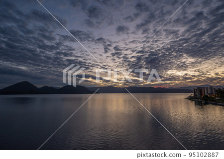 初升的太陽改變了洞爺湖上雲層的顏色 95102887