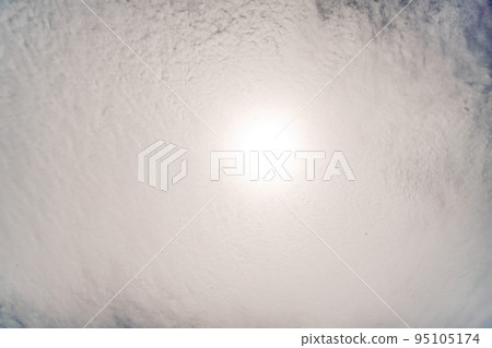 Fluffy clouds in the blue sky. The sun shines through them 95105174