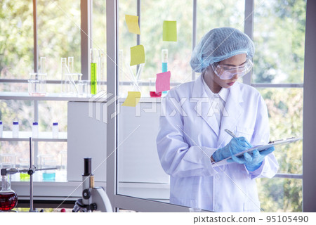 Researcher biology chemistry. Asian Female technician laboratory using microscope blood test. Asian Woman scientist hand write note research in medical lab look at science microscope medical test Researcher biology chemistry. Asian Female technician laboratory using microscope blood test. Asian Woman scientist hand write note research in medical lab look at science microscope medical test 95105490