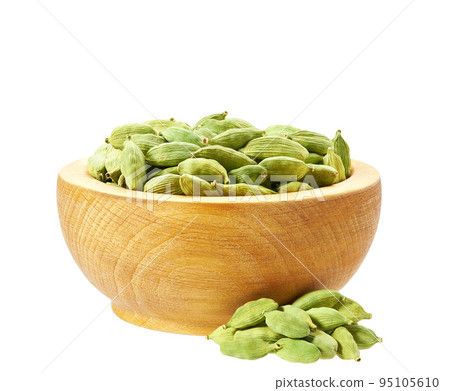 Wooden plate with green cardamom seeds isolated on white. Wooden plate with green cardamom seeds isolated on white. 95105610