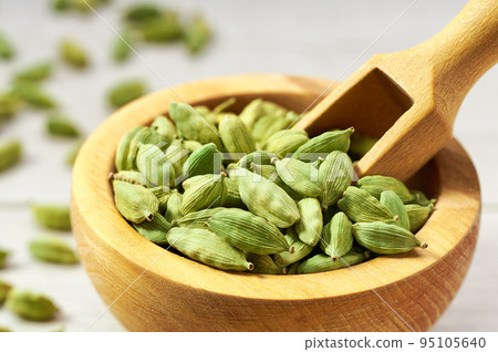 Cardamom pods on a white wooden kitchen table, close up. Cardamom pods on a white wooden kitchen table, close up. 95105640