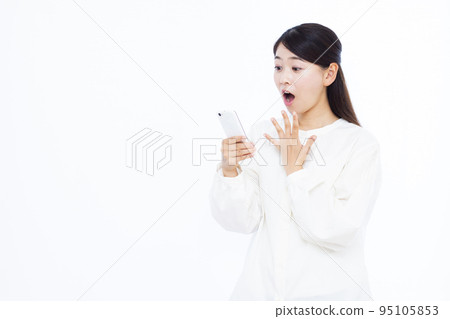 一個 30 多歲的女人拿著智能手機微笑著驚訝 95105853