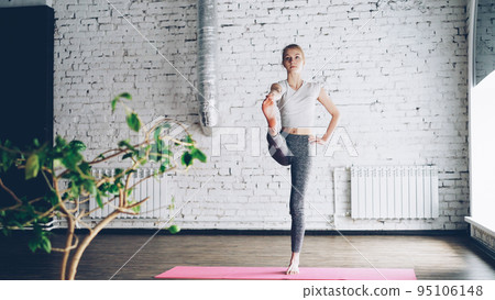 Starting female yoga student is doing sequence of balance exercises in one-to-one yoga class in nice studio. She is sometimes awkward but making good progress. Learning yoga concept. Starting female yoga student is doing sequence of balance exercises in one-to-one yoga class in nice studio. She is sometimes awkward but making good progress. Learning yoga concept. 95106148