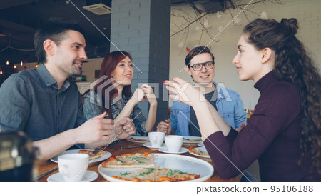 Close friends are sharing funny stories gesturing and laughing while having lunch in modern local cafe. Positive emotions, happy people and tasty food concept. Close friends are sharing funny stories gesturing and laughing while having lunch in modern local cafe. Positive emotions, happy people and tasty food concept. 95106188