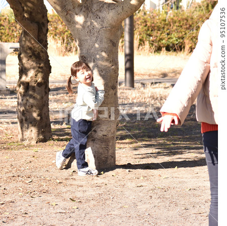 Mother and girl playing together in the park Mother and girl playing together in the park 95107536