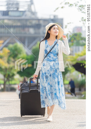 A young woman pulling a suitcase and sightseeing in Nagoya 95107881