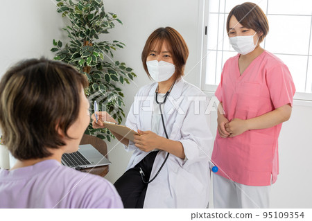 Female doctor interviewing a patient Female doctor interviewing a patient 95109354