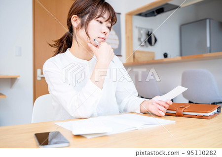 Young woman living room household account book Young woman living room household account book 95110282