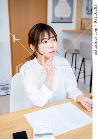 Young woman living room household account book Young woman living room household account book 95110283