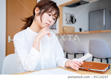Young woman living room household account book Young woman living room household account book 95110287