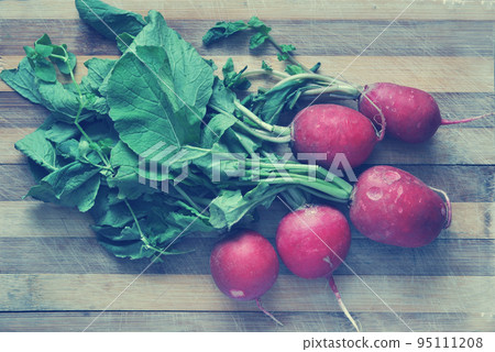 Red radishes on a cutting board Red radishes on a cutting board 95111208