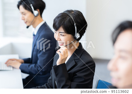 Young businessman working in a call center Young businessman working in a call center 95113602