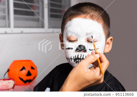 Asian mother and kid son getting makeup halloween face painting look like ghost 95113608