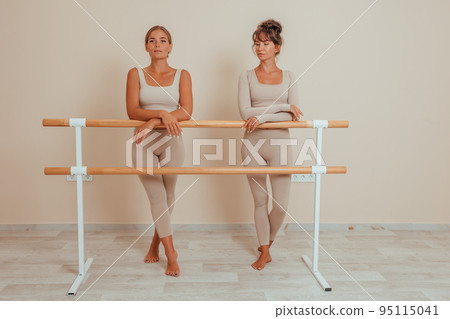 Well looking middle aged womans, fitness instructor in beige sportswear, preparing for stretching and pilates on yoga mat in the gym. Female fitness yoga concept. Healthy lifestyle harmony, meditation 95115041