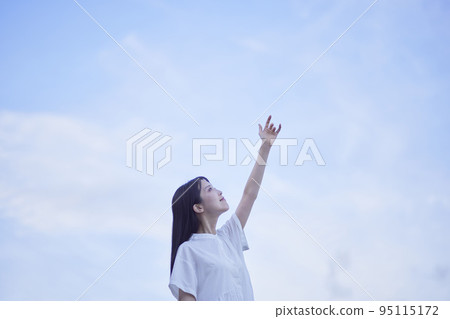 Blue sky at sunset and a woman wearing a white dress 95115172