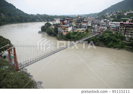 Lakshman Jhula a suspension bridge across the river Ganges. Bridge connects the villages of Tapovan to Jonk.  Rishikesh, Uttarakhand, India 95115211