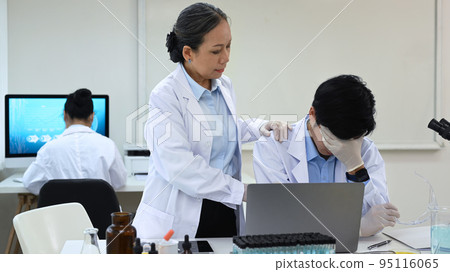 Image of senior woman scientist comforting stressed male with problems results of the experiment 95116065