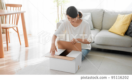A woman opening a cardboard mail order image 95116202