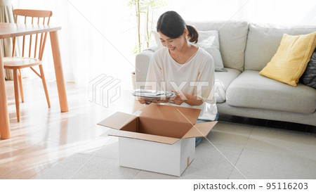 A woman opening a cardboard mail order image 95116203